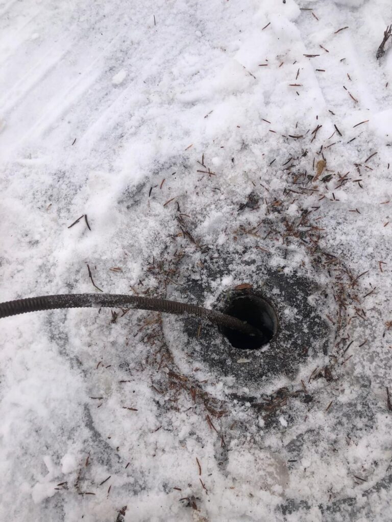 On passe un furet dans le drain pris dans la glace pour le déboucher et laisser s'écouler l'eau de fonte.