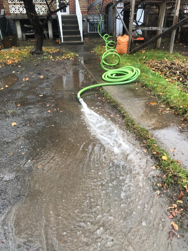 L'eau pompée du toit est évacuée par un boyau loin des fondations du bâtiment.