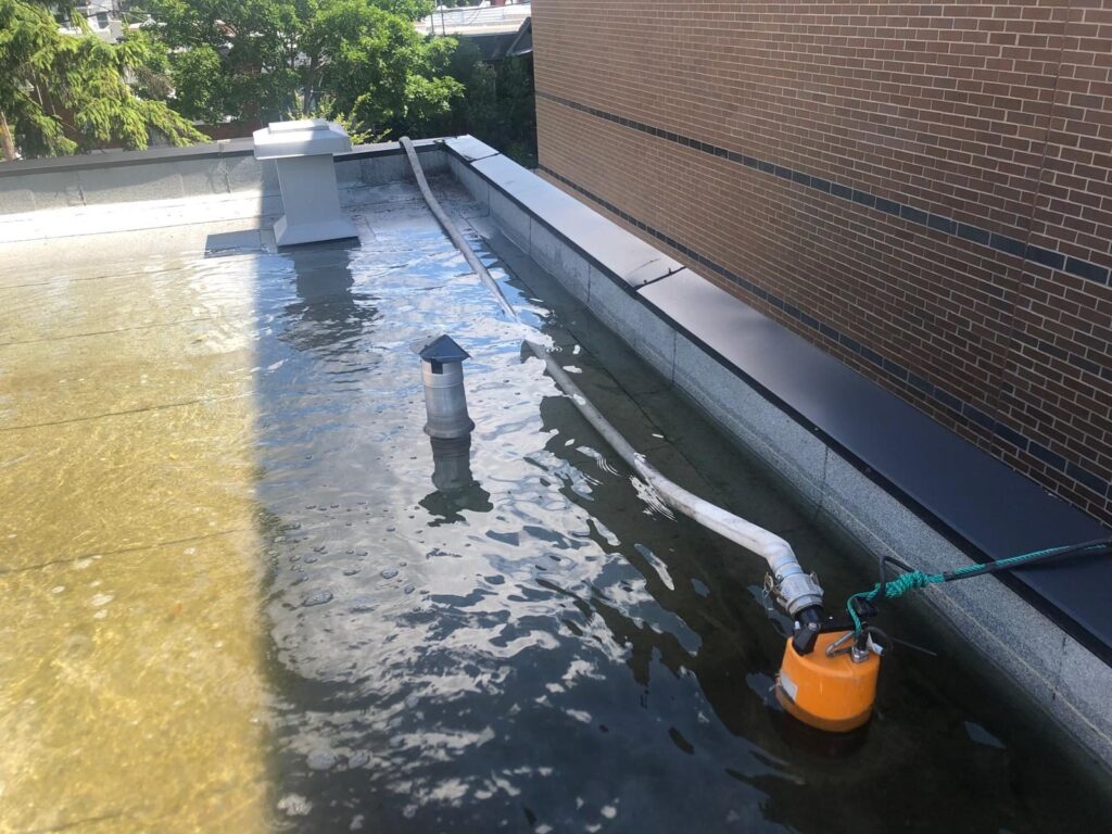 Une pompe submersible installée dans le coin du toit où l'eau s'accumule.