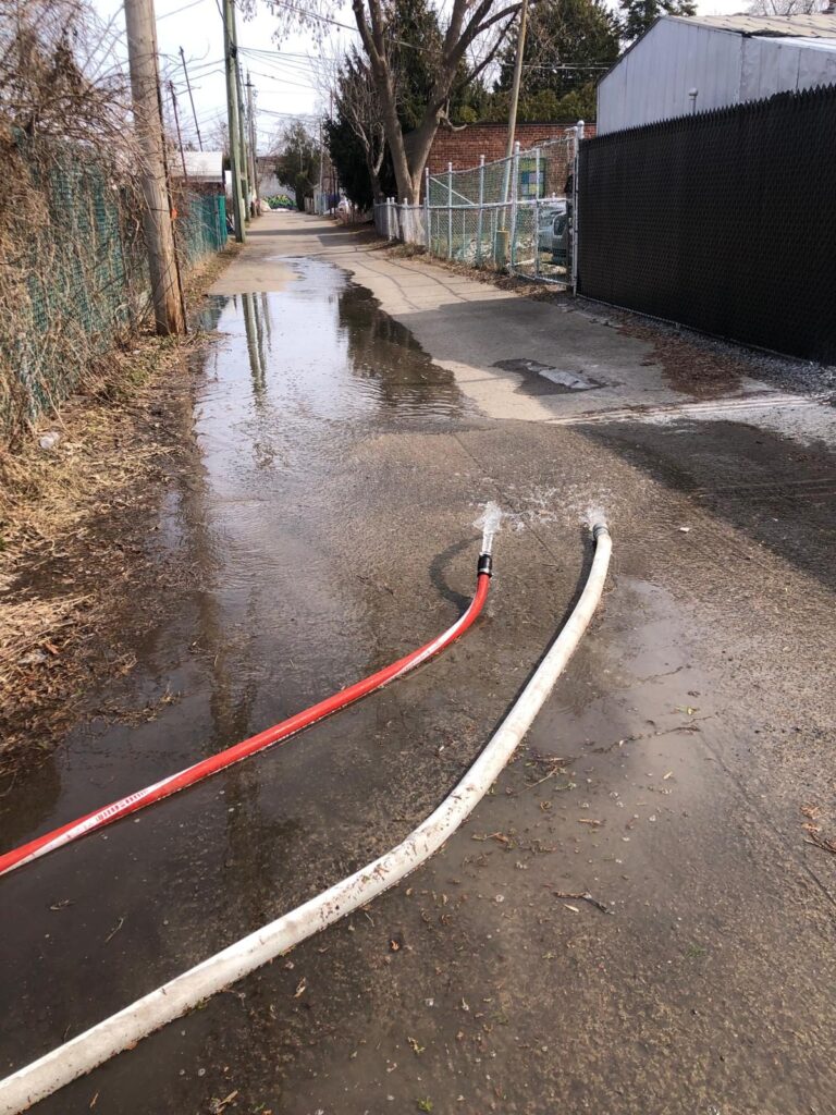 Dans la ruelle, les boyaux évacuent l'eau pompée du toit.