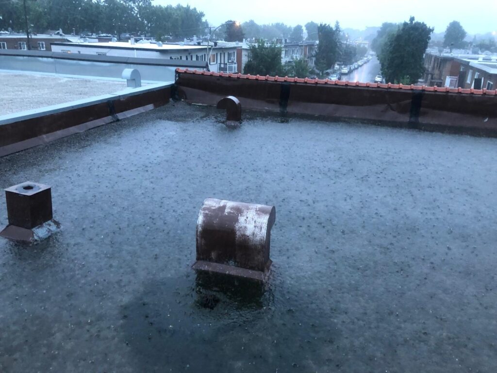 Sous la pluie, le toit ne se vide plus : l'eau n'a nulle part où aller.