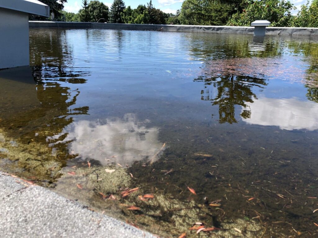 Toit plat sous l'eau, avec des débris au fond.