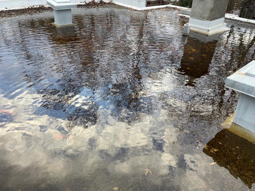 Toit inondé qui reflète le ciel.